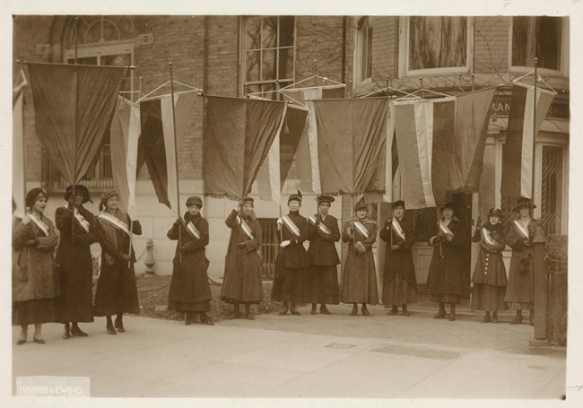 NWP members posing in front of headquarters holding banners