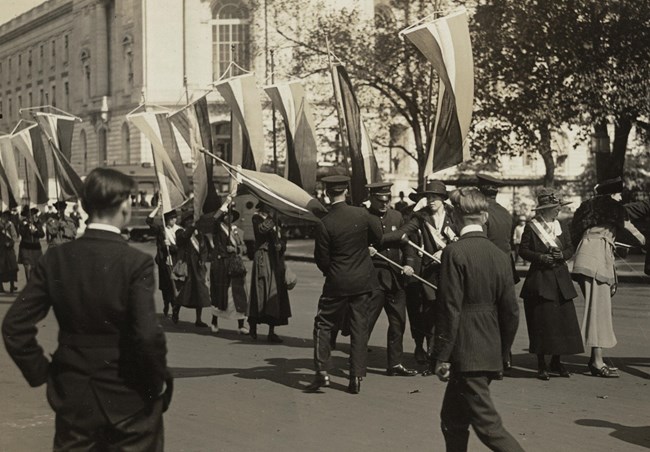Policemen forcibly seizing banners from suffragists outside the Capitol