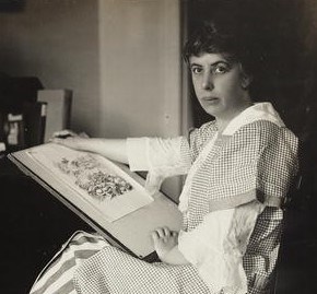 Suffrage cartoonist Nina Allender, seated with a cartoon in progress in her lap