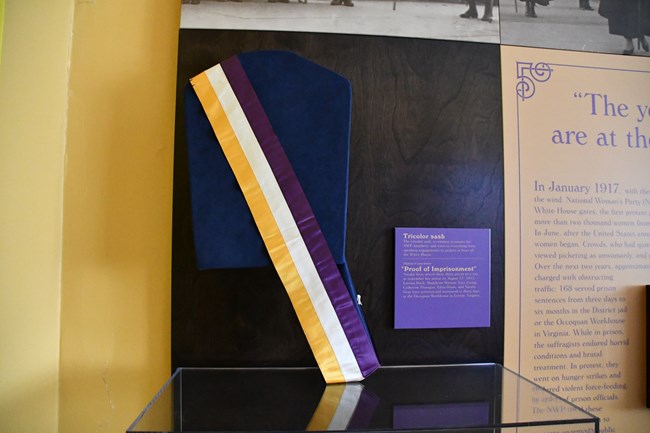 Purple, white, and gold suffrage sash on display in the Belmont-Paul Women's Equality NM museum