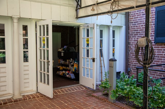 A set of white and glass doors open out to a brick patio.