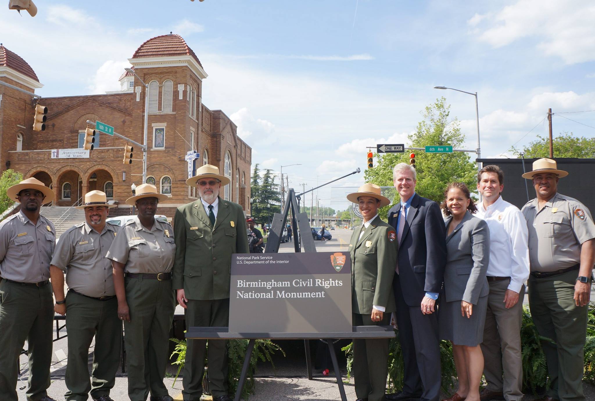 Dignitaries stand on either side of a sign that reads Birmingham Civil Rights National Monument
