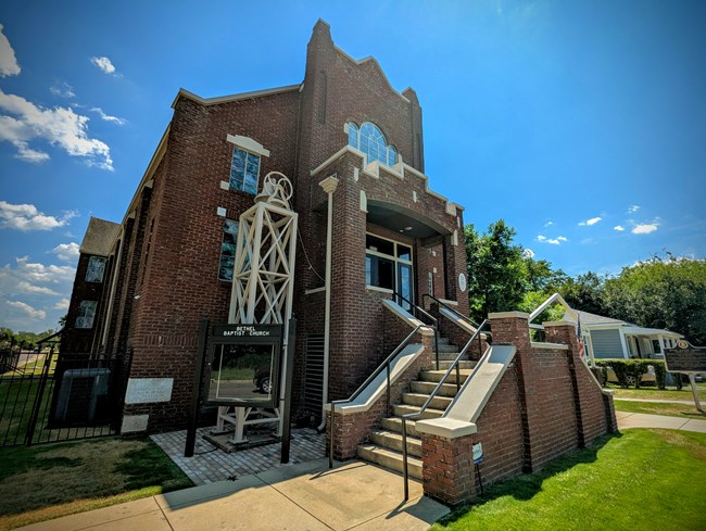 A large church with stand glass windows and a grand entrance on the front.
