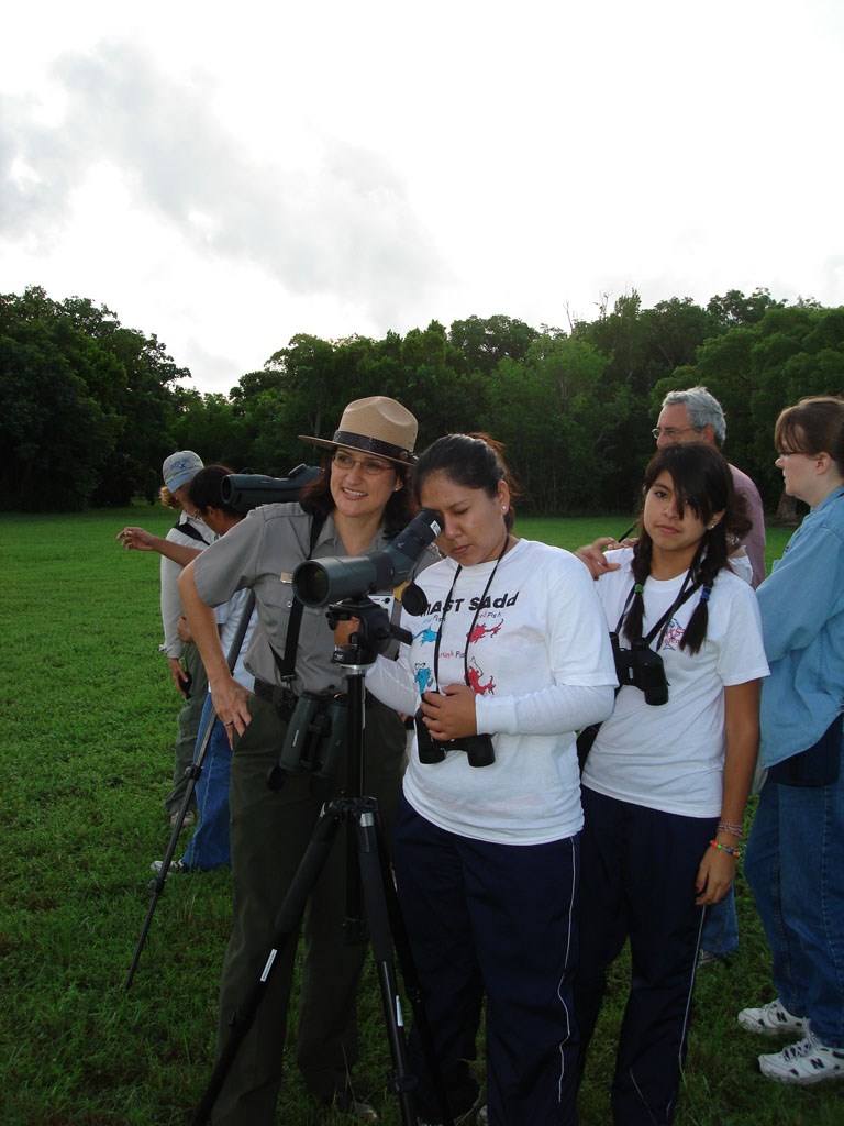 A park ranger shows a visitor how to use a spotting scope