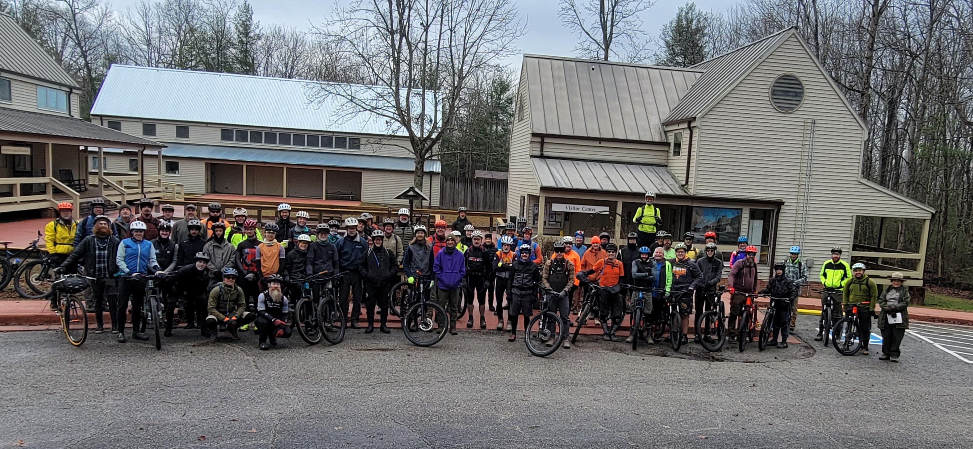 A large group of mountain bikers posing for a picture in the winter.