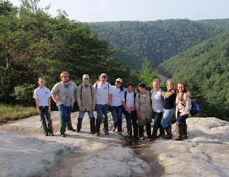 Group of youth workers standing on overlook rock
