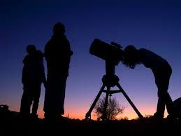 people sky gazing through a telescope