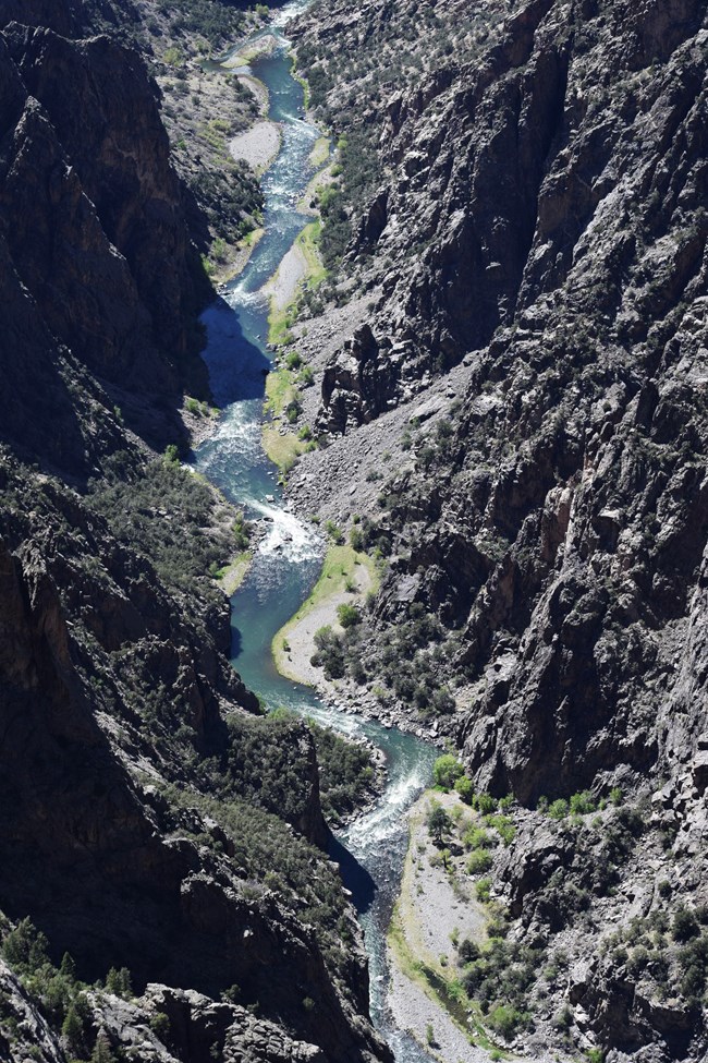 A view into a steep, deep canyon with a raging river below
