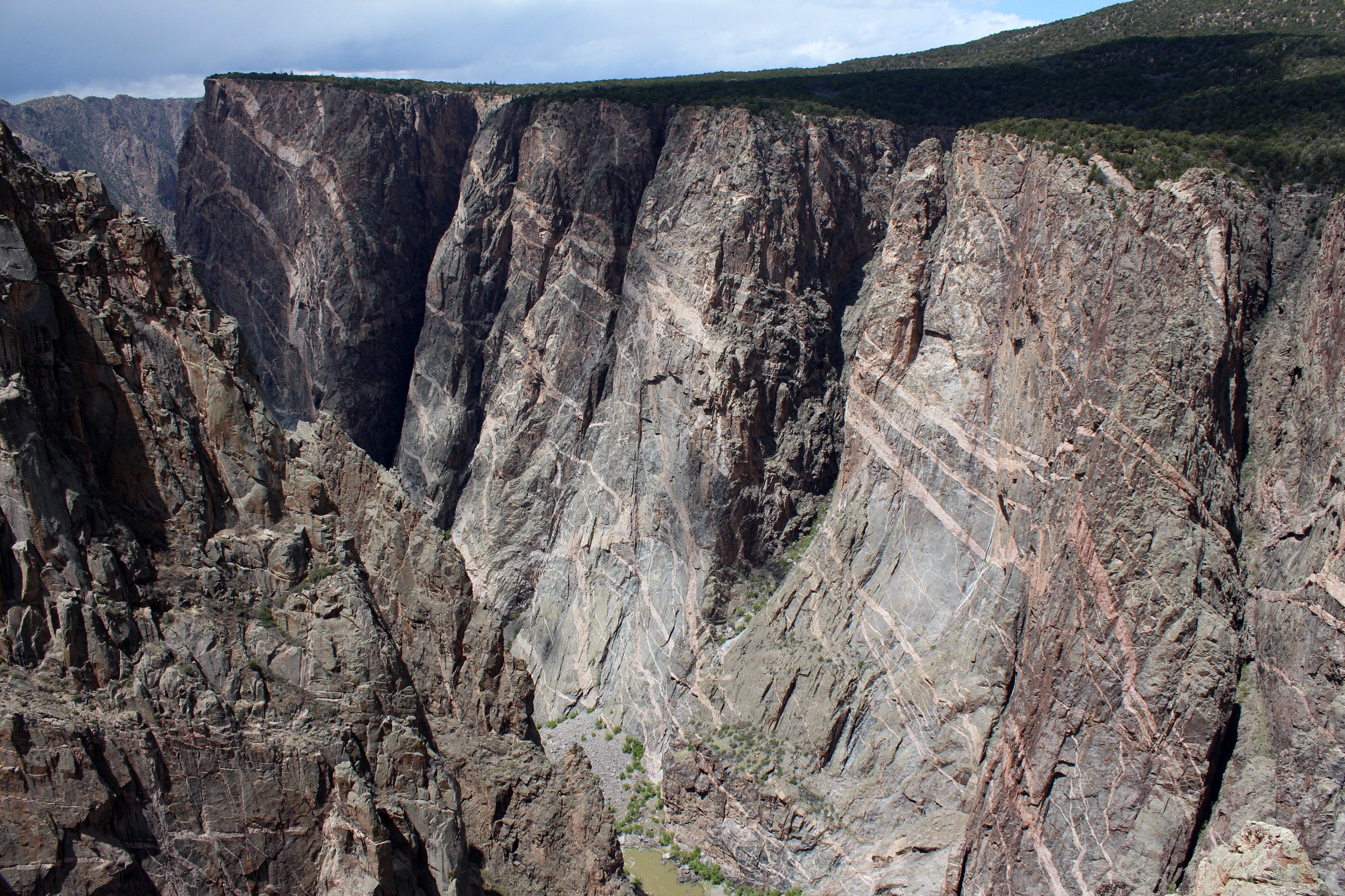 A large canyon wall with varying colored geologic layers
