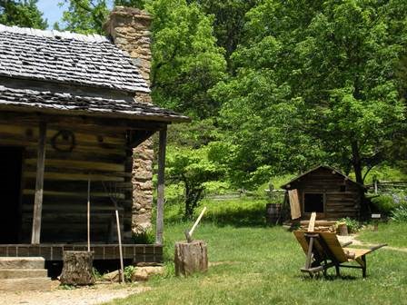 A log cabin surrounded by a yard and forest at Humpback Rocks Farm.