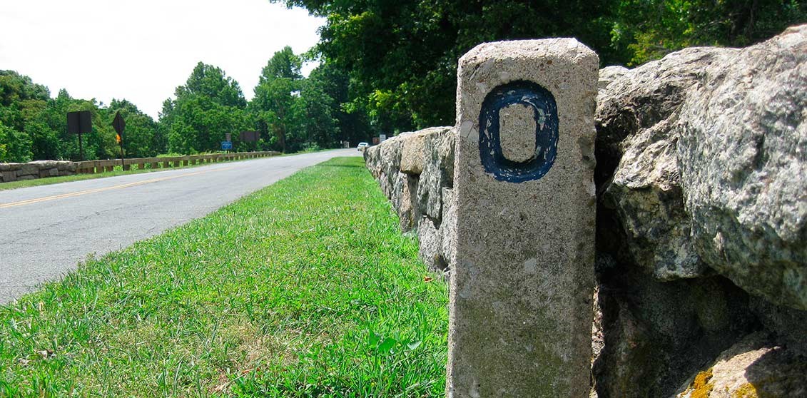 A concrete milepost marker with a 0 on it marks the beginning of the parkway in Virginia