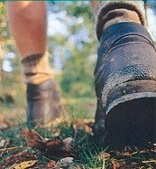 Close up shot of a hiker's boots as he walks on a trail