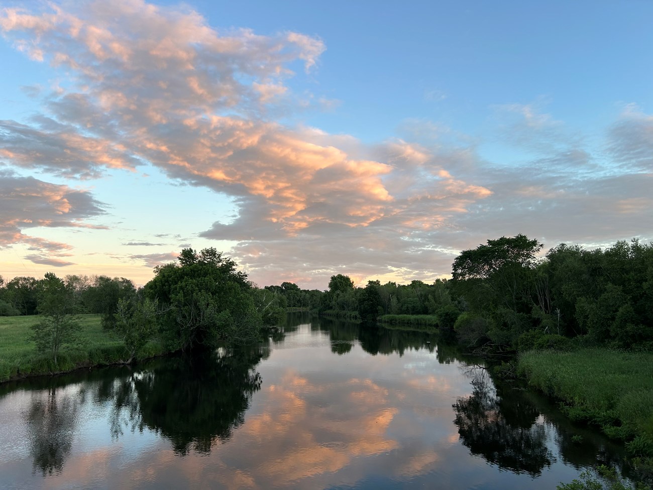 River with tree lined sides at sunset