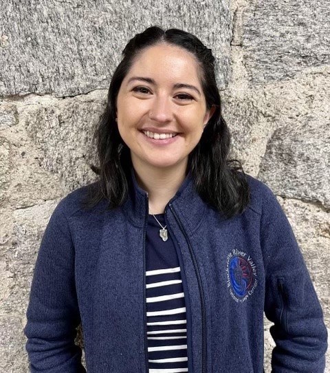 Woman with black hair wearing a blue sweatshirt