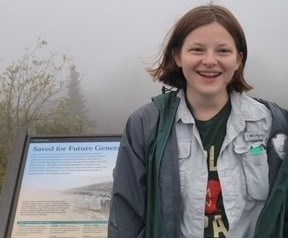 Woman standing in front of wayside on foggy day