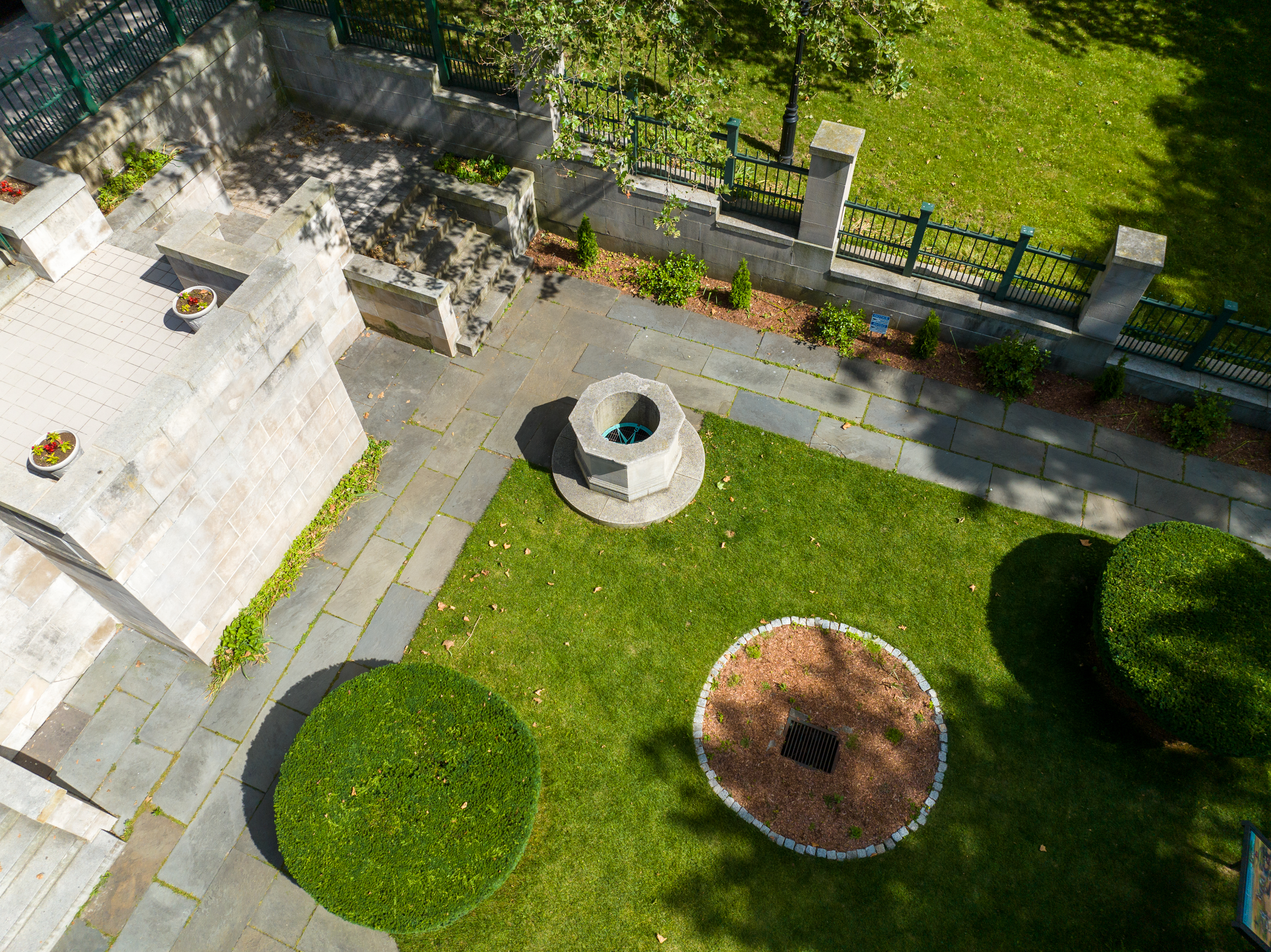 Aerial picture of the Hahn Memorial. Green grass is surrounded by stone paths and a circular stone well