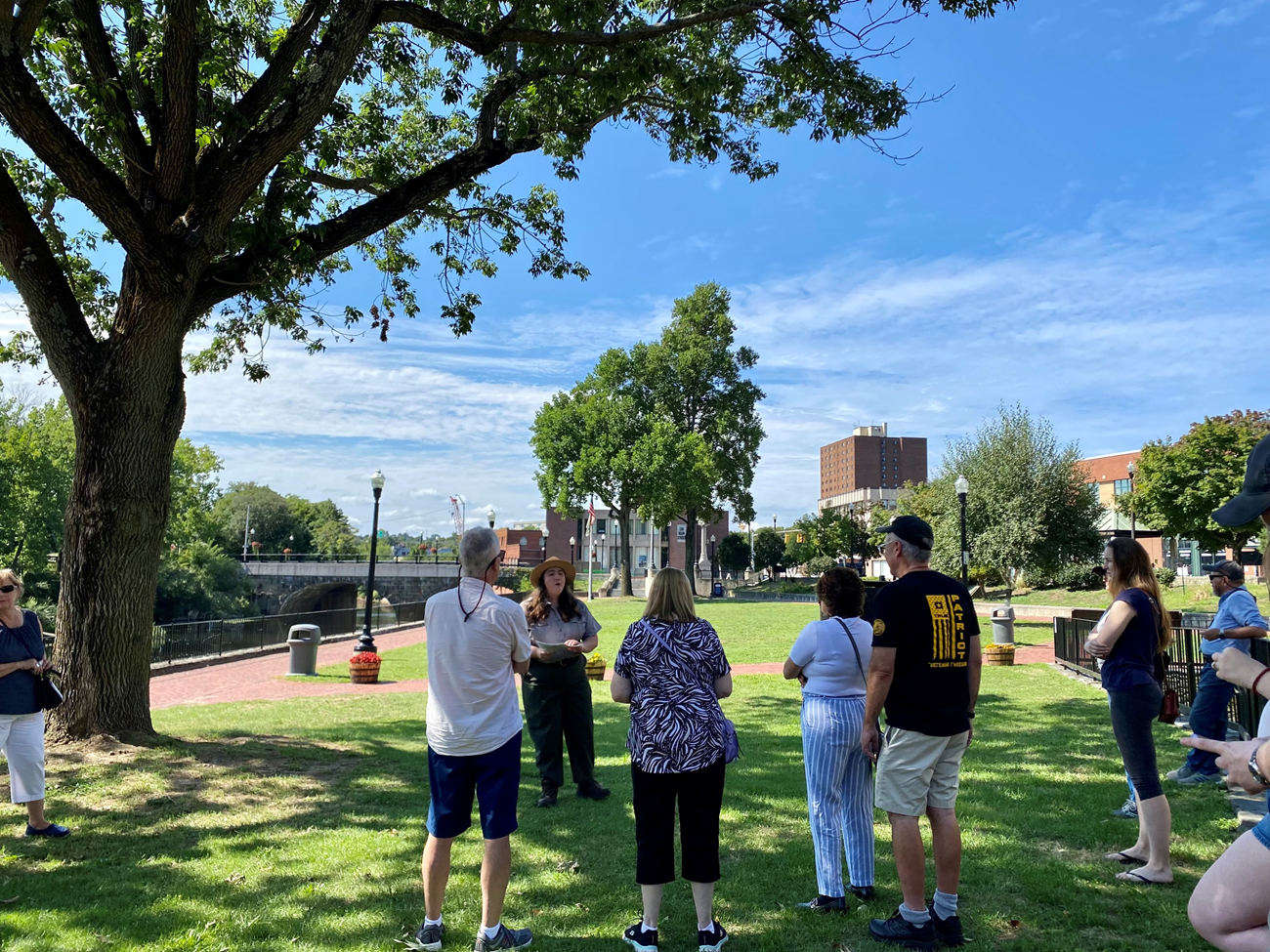 Park Ranger addresses group of visitors alongside Blackstone River