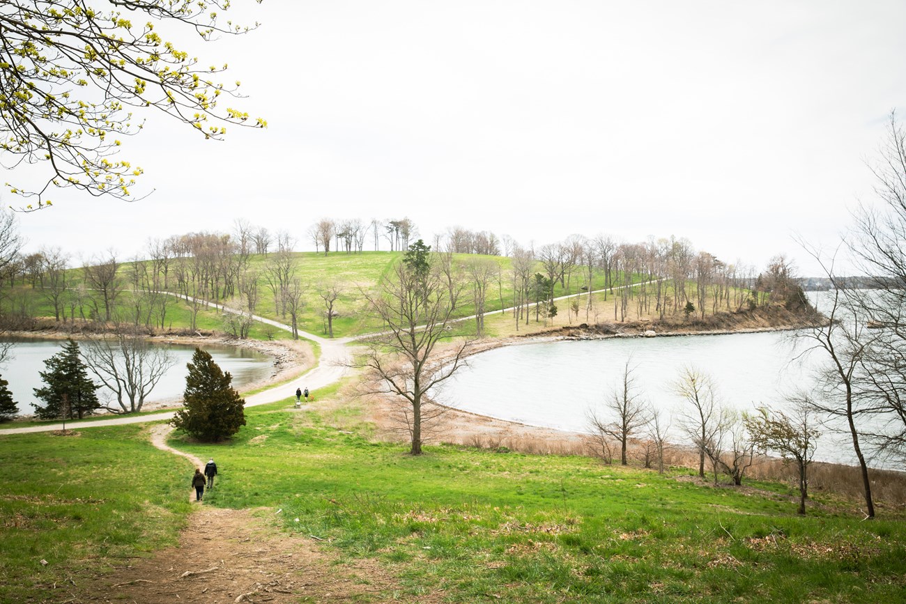 small neck with a path leading to a grassy hill.