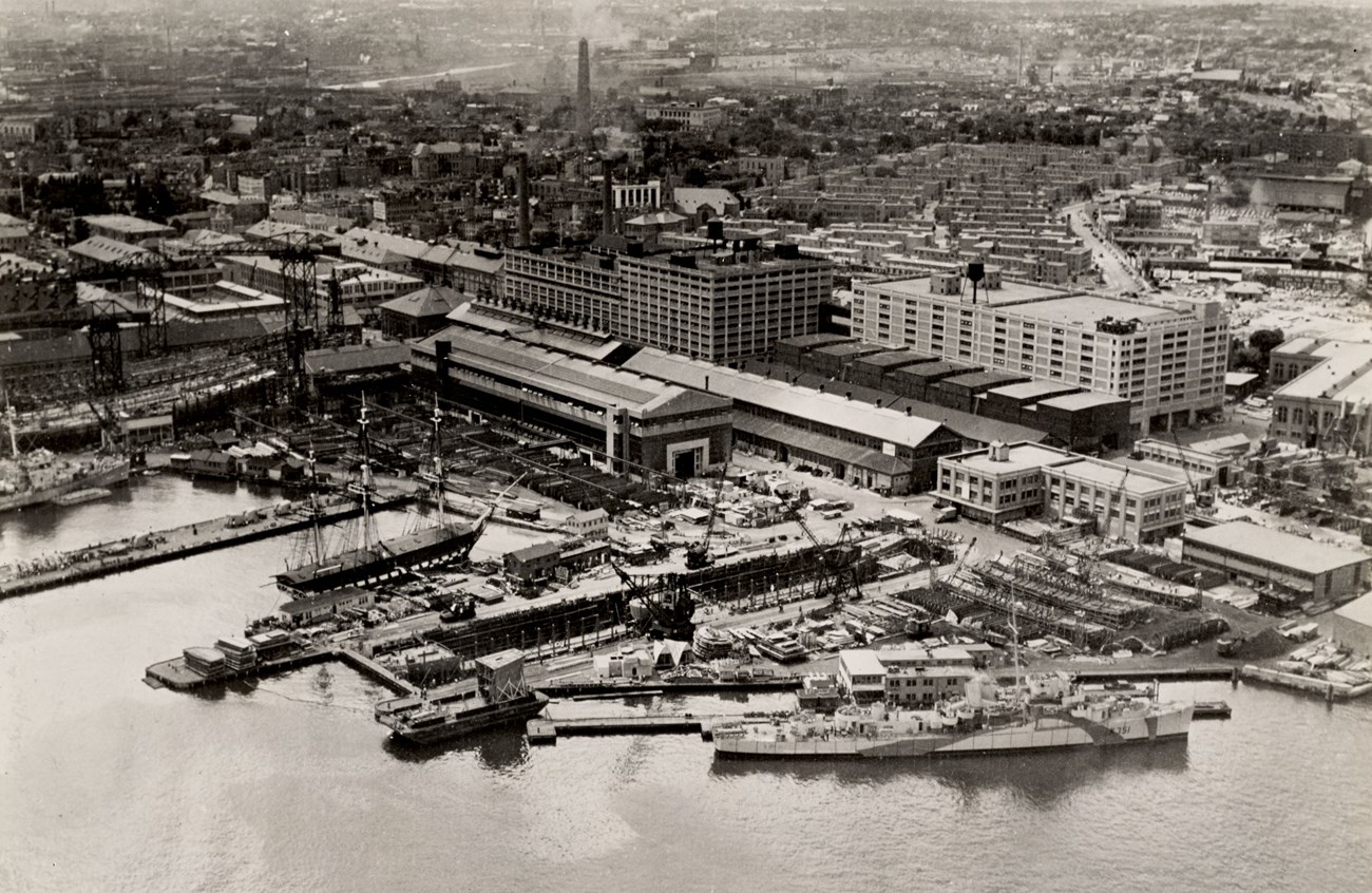 Aerial view of the Charlestown Navy Yard and its piers; USS Constitution is docked at the Navy Yard.
