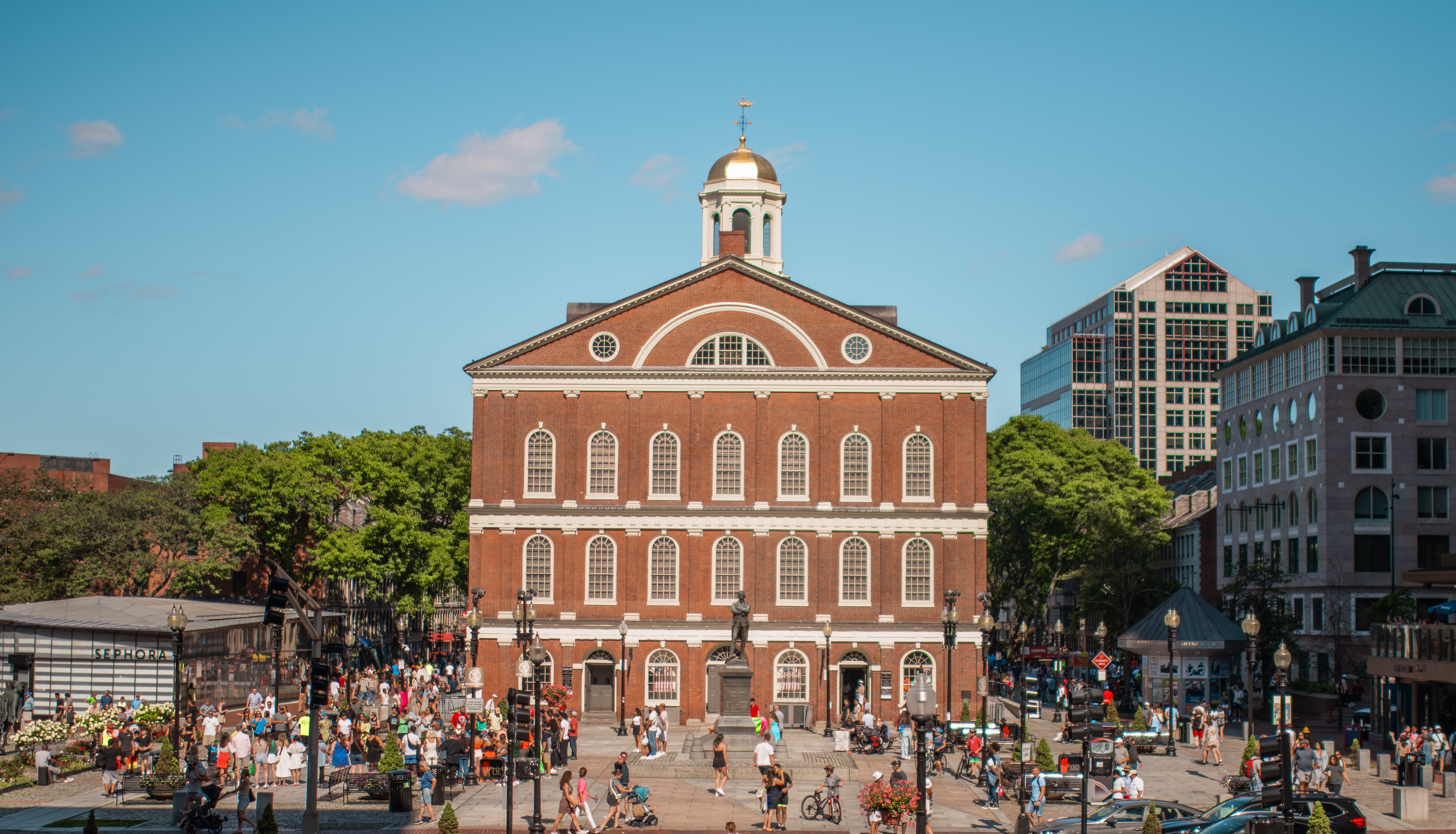 Faneuil Hall with dock square in front of it filled with people.