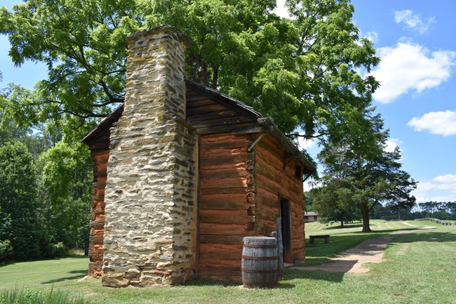 A paved path on a slopped hill leads A rustic cabin.