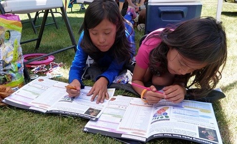 Two park visitors working on completing their Junior Ranger Books.