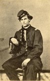 Photo of Oscar Kelton, 95th OH Infantry, taken in 1863. Oscar is sitting in a chair in his military uniform looking straight ahead.