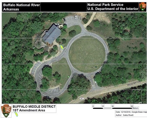 Google Earth photo showing figure eight driveway entrance to visitor center in center with yellow trapezoid near junction of circles for 1st amendment area