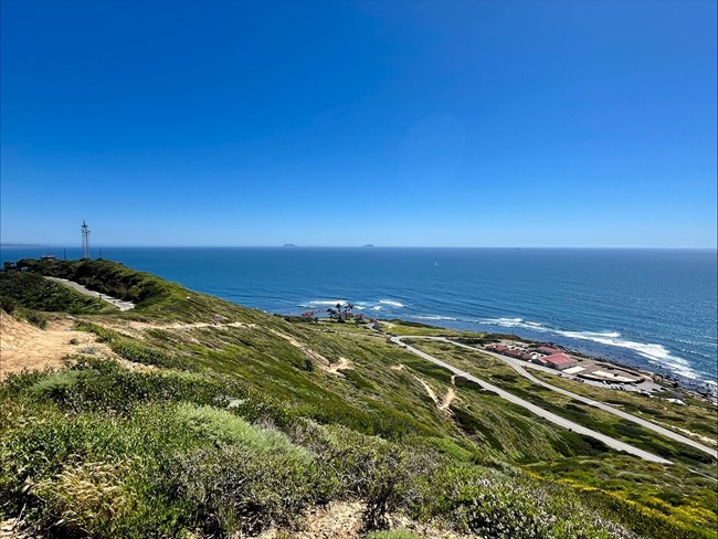 Scenic view of a trail, hills and ocean.