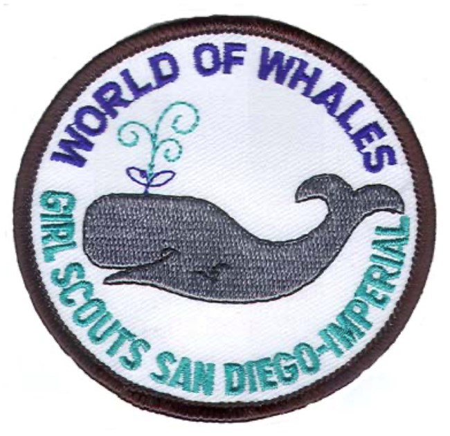 A circle patch with a black border. A gray whale is in the middle. Text above the whale says World of Whales. Text below the whale says Girl Scouts San Diego-Imperial