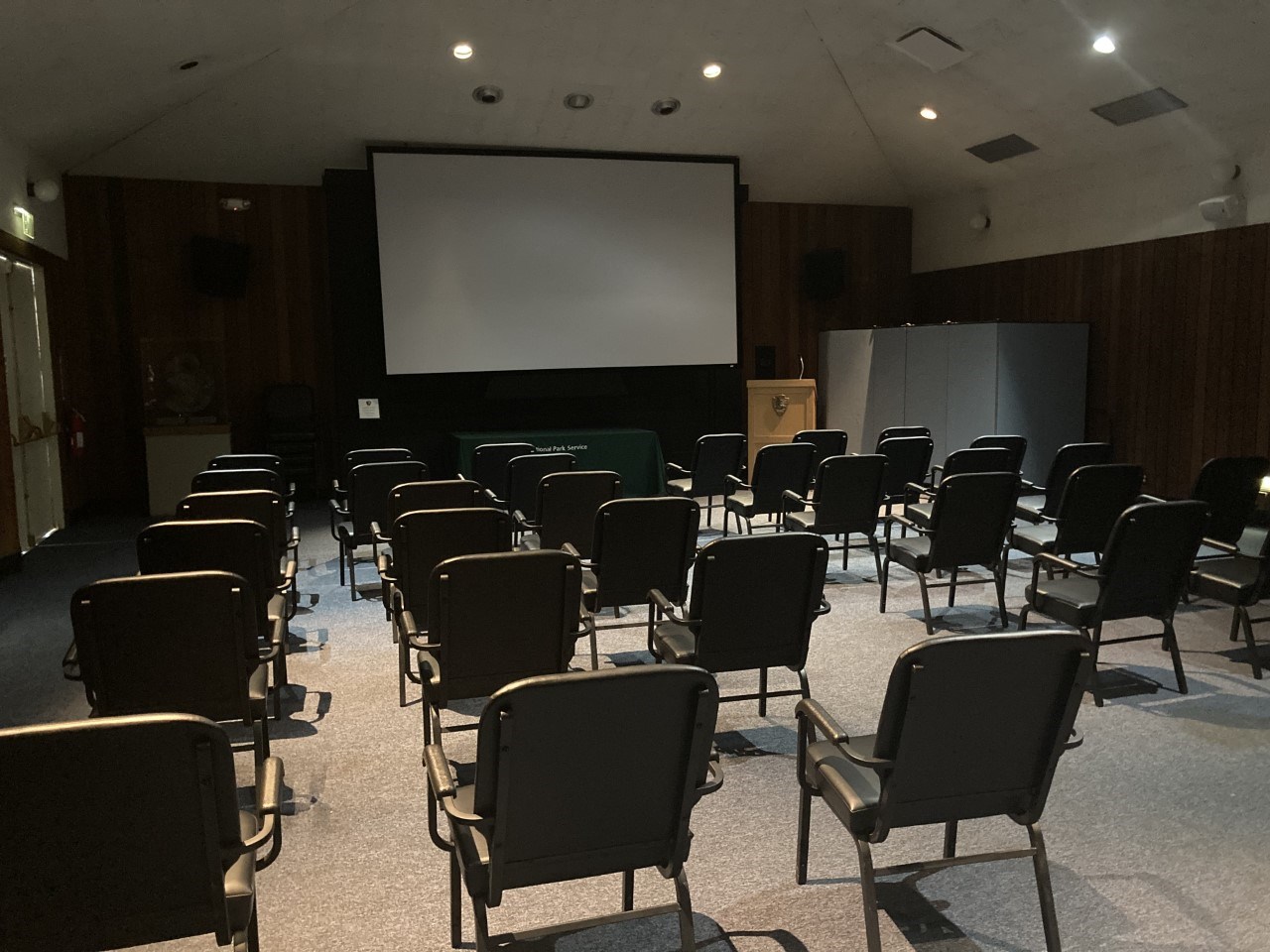 Auditorium with chairs pointed at a screen.