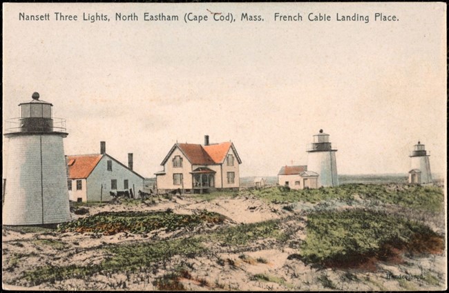 Three lighthouses are visible on a sea cliff.