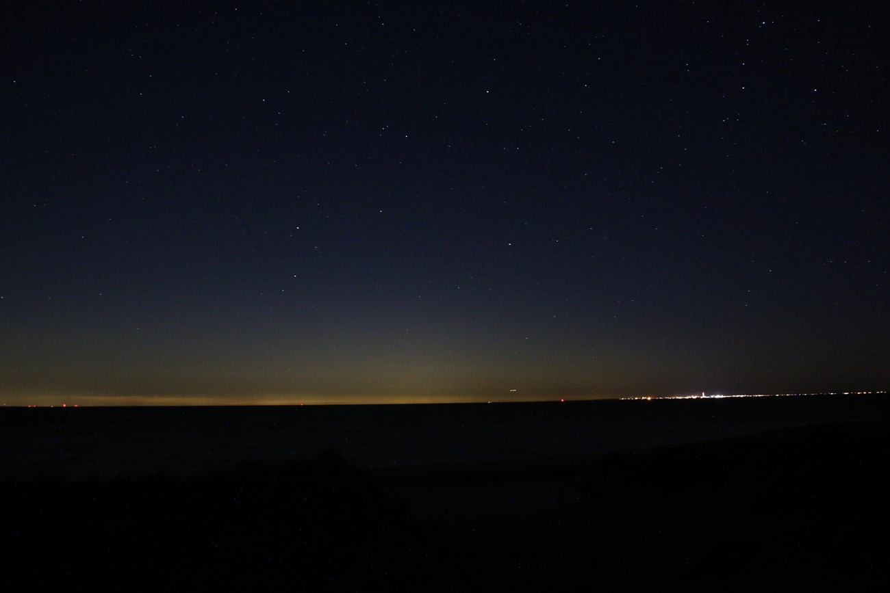 Stars in the night sky are crowded out by light pollution from nearby towns.