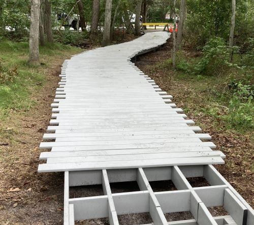 White boardwalk planks are replaced on a trial.