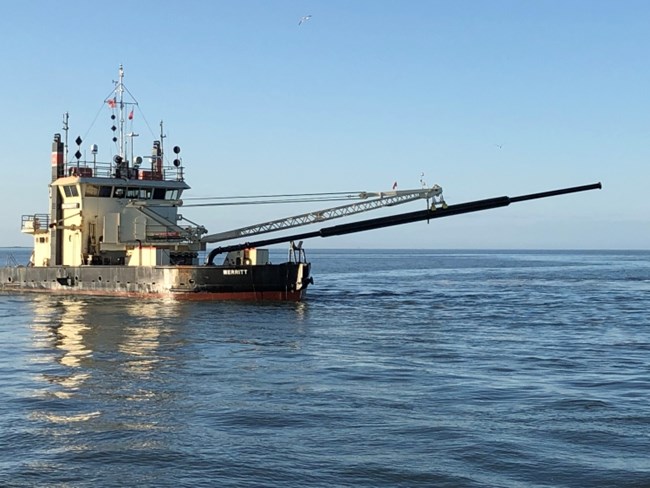 Side view of an Army Corps of Engineers dredging vessel.