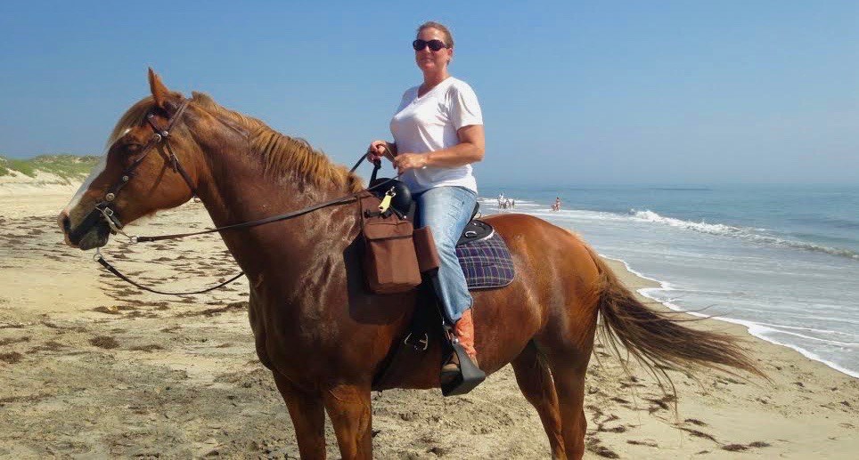 Woman riding a horse on the beach