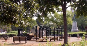 Playground equipment in Stanton Park, with the statue of General Nathanael Greene in the background.