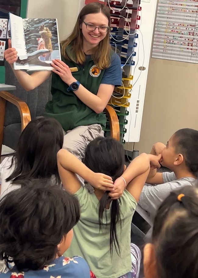 A ranger reads a story to a group of students.