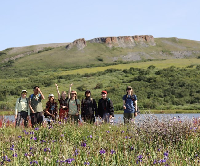 A group of youth standing in front of vegetation covered hills in Cape Krusenstern National Monument