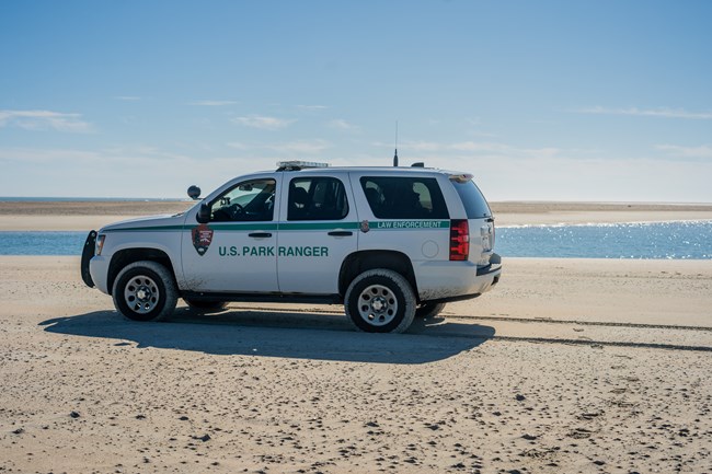 white law enforcement vehicle on the sand