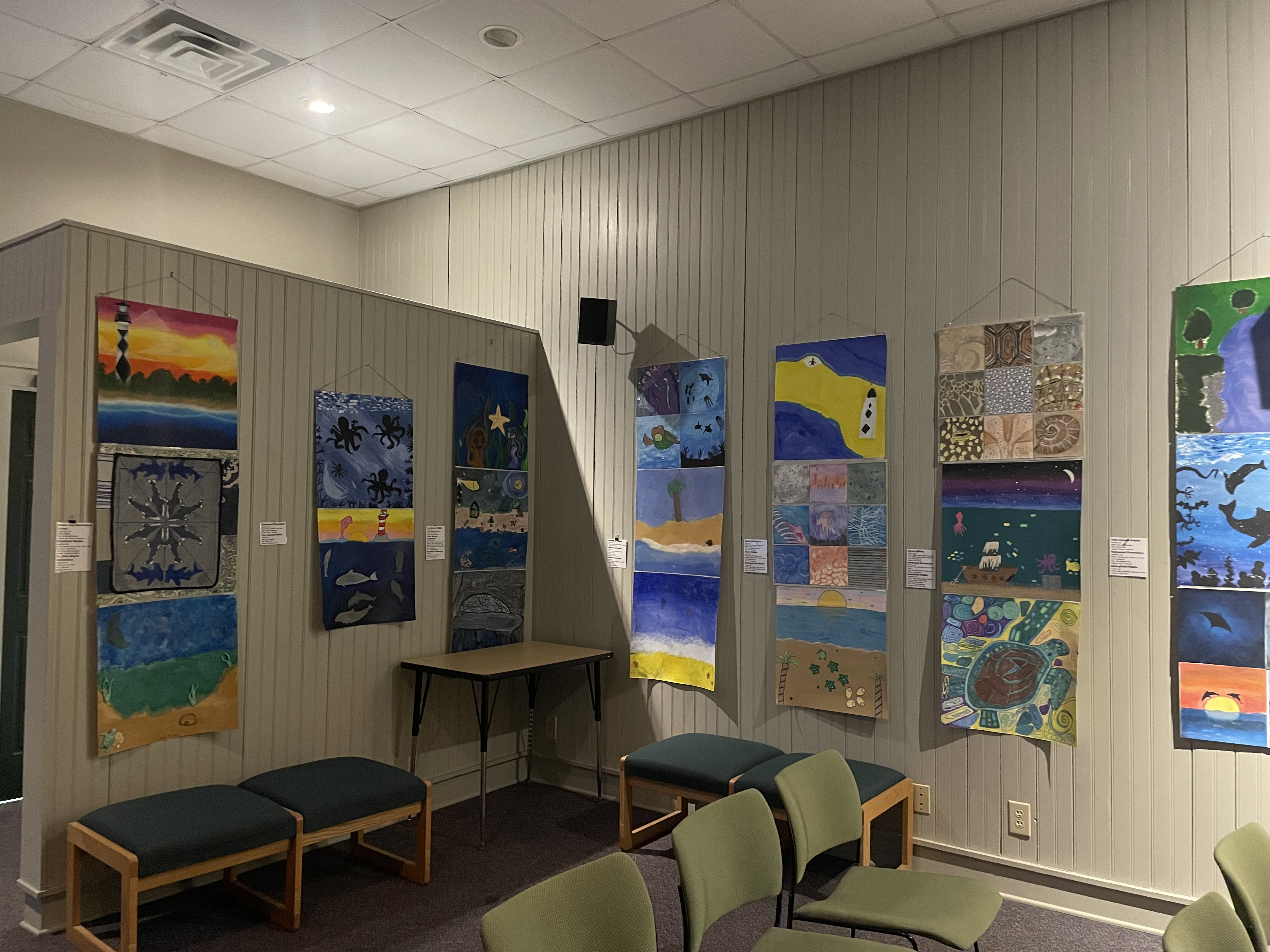 Pictures hanging on a wall with benches below