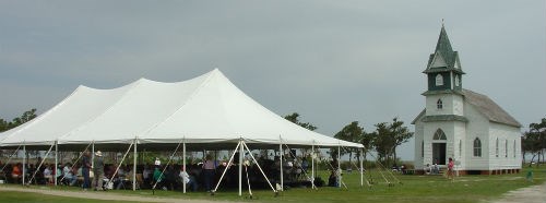 Visitors under a tent in front of the Portsmouth Village Church