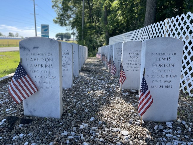 White military headstones decorated with US flags.