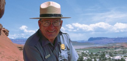 A park ranger wearing a flat straw hat