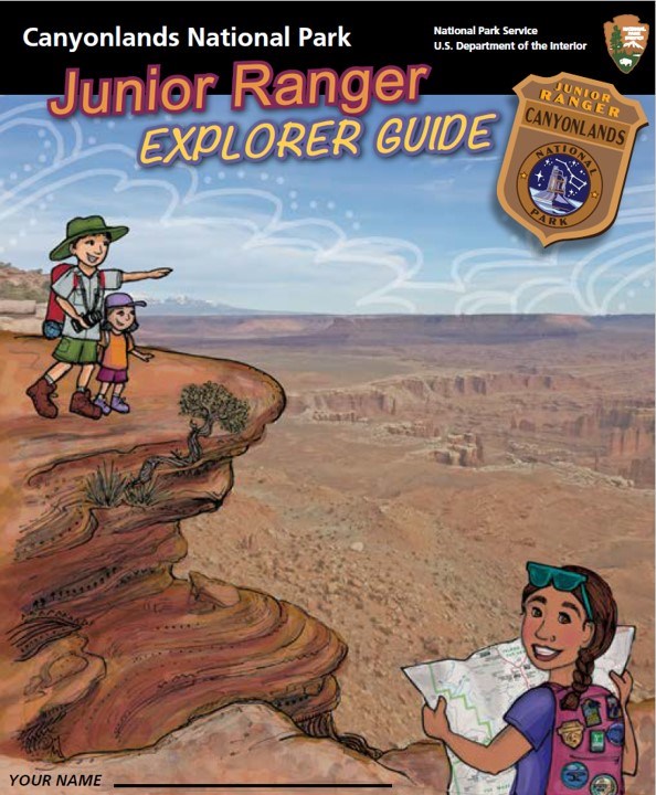 drawing in which a boy and girl stand on a canyon rim. The boy points to the distance. In foreground, another girl looks at a map.