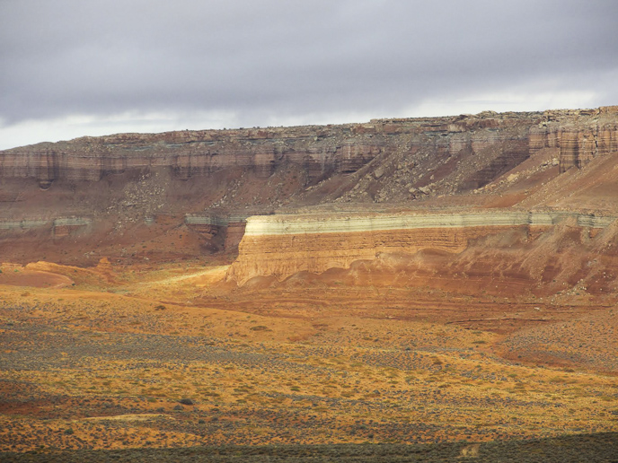 The light-colored, grayish-green layer in the middle of the escarpment is the Curtis Formation (below the Sommerville).