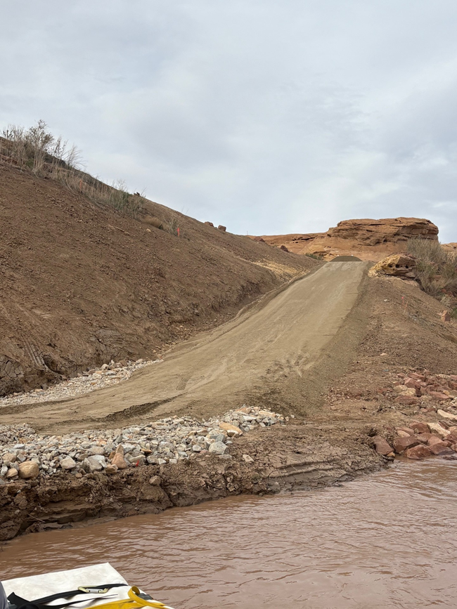 Image of a dirt ramp alongside a rocky river shoreline