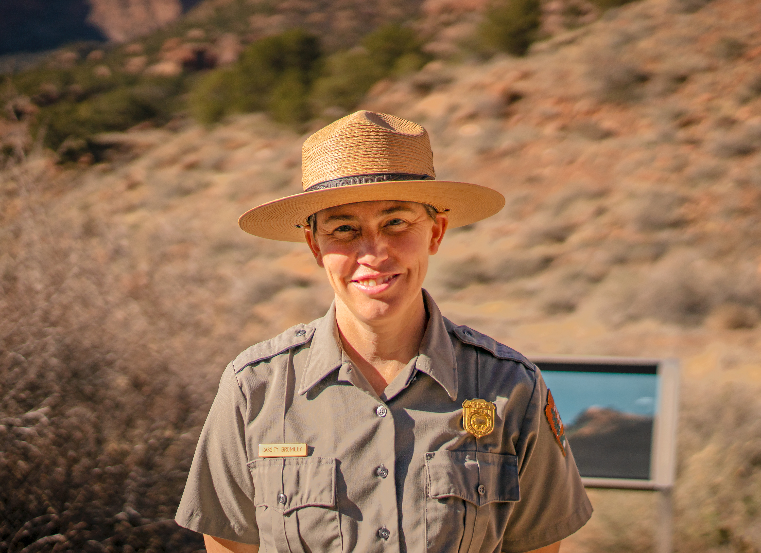 Photo of Superintendent Cass Bromley in NPS ranger uniform outside with a desert landscape in the background.