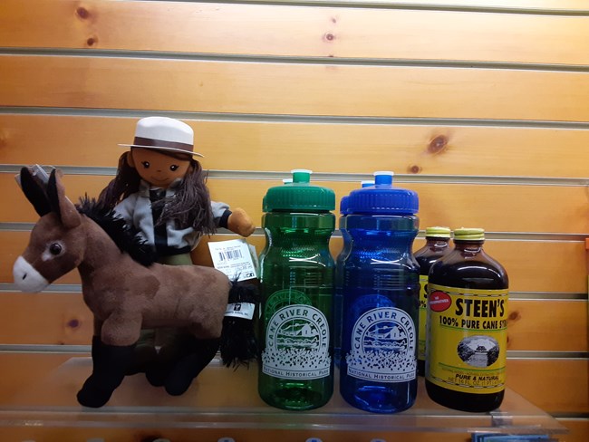 A display of items available for purchase including toys, water bottles, and cane syrup.