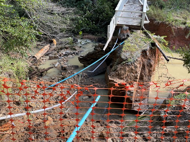 Erosion near dam along with broken pipes.